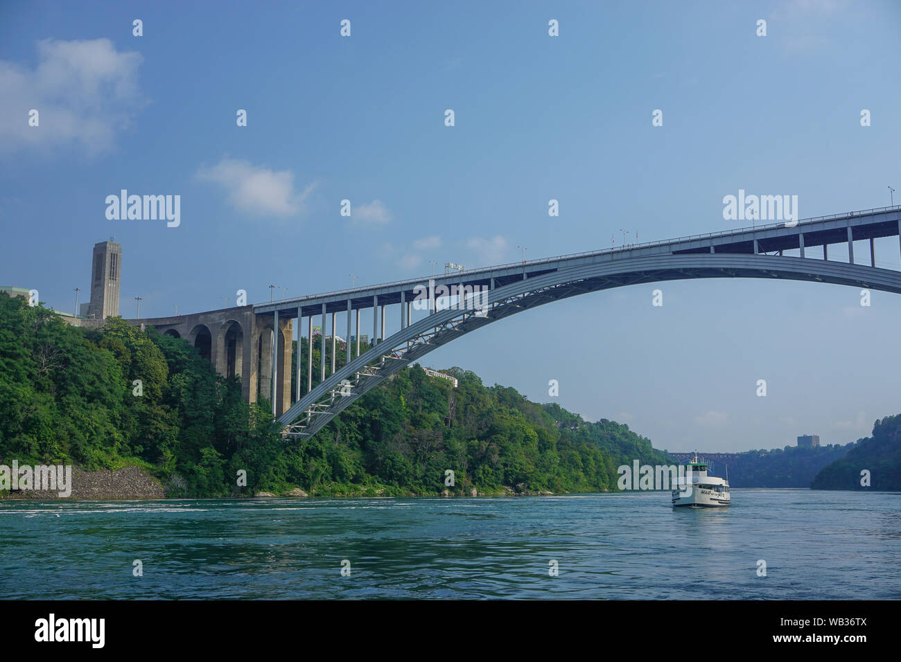 Niagara Falls, Ontario, Canada: Il Rainbow Bridge internazionale sulla gola del Niagara, il Carillon Rainbow Tower, una cameriera della nebbia la barca turistica. Foto Stock