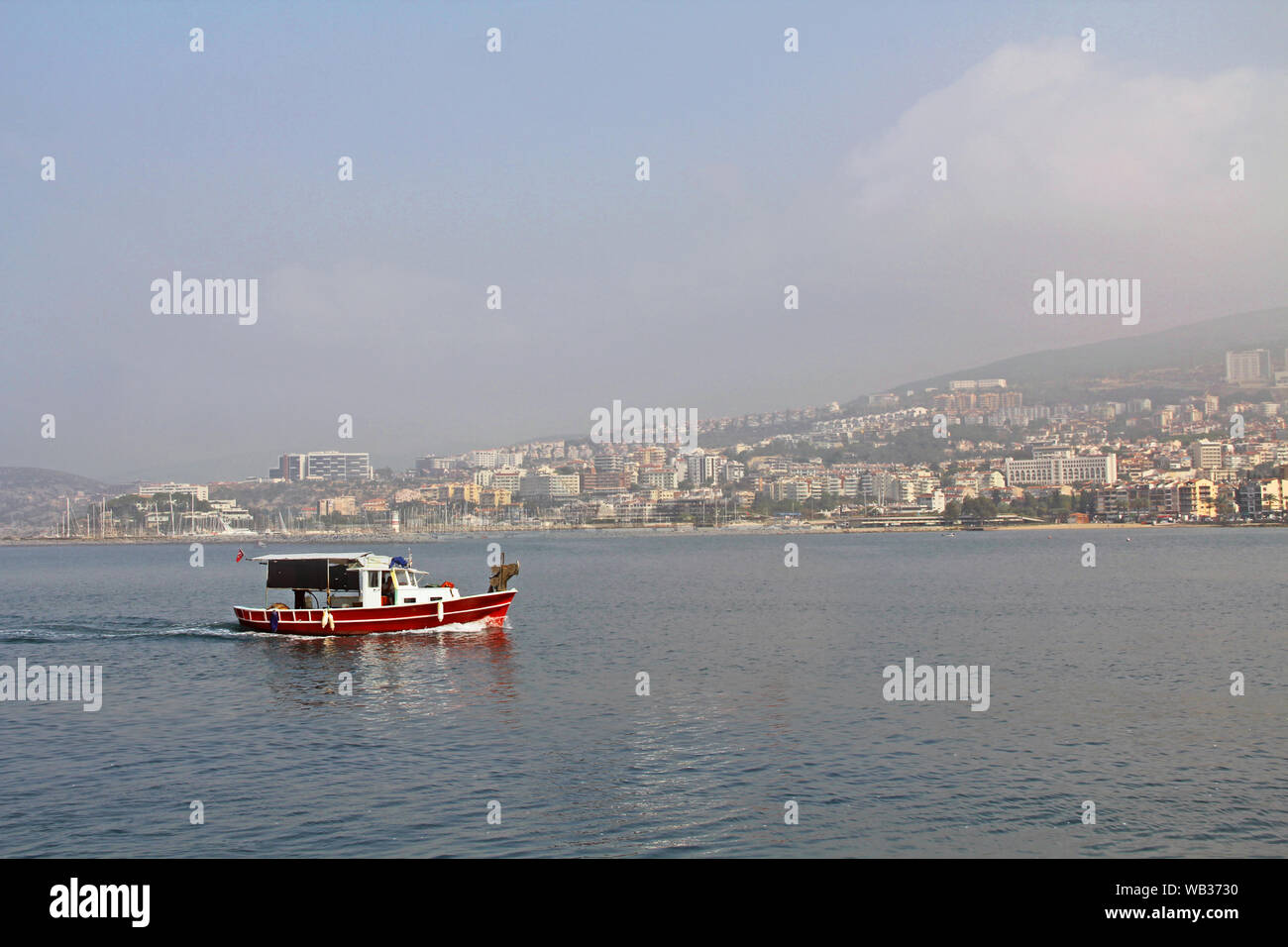 Barca da pesca con la città di Kusadasi, Turchia in background Foto Stock