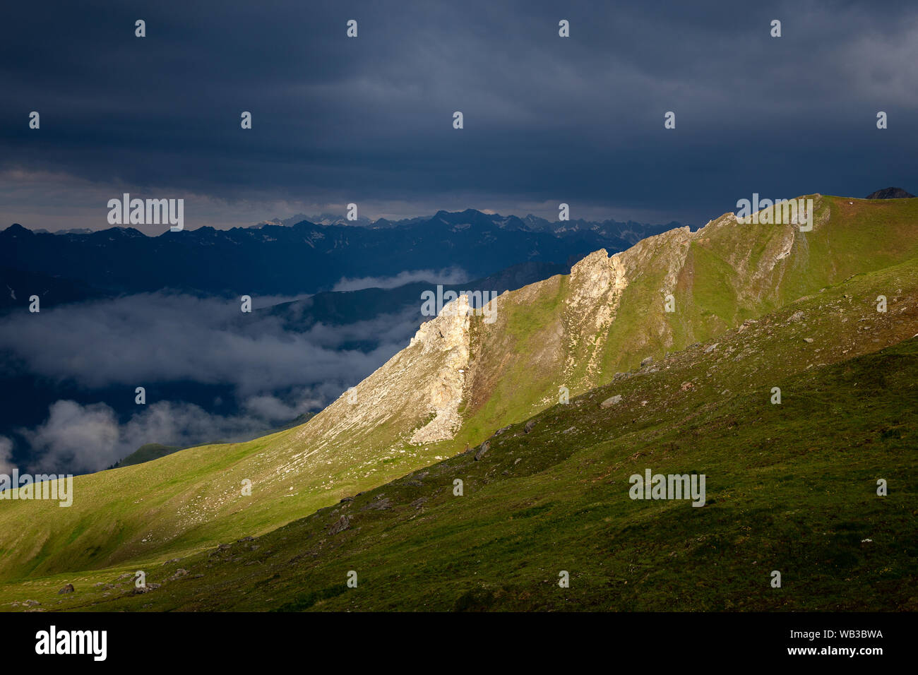 La luce del sole sulle montagne. Suggestivo paesaggio di montagna, cielo nuvoloso scuro. Glocknergruppe massiccio. Alpi austriache. Foto Stock