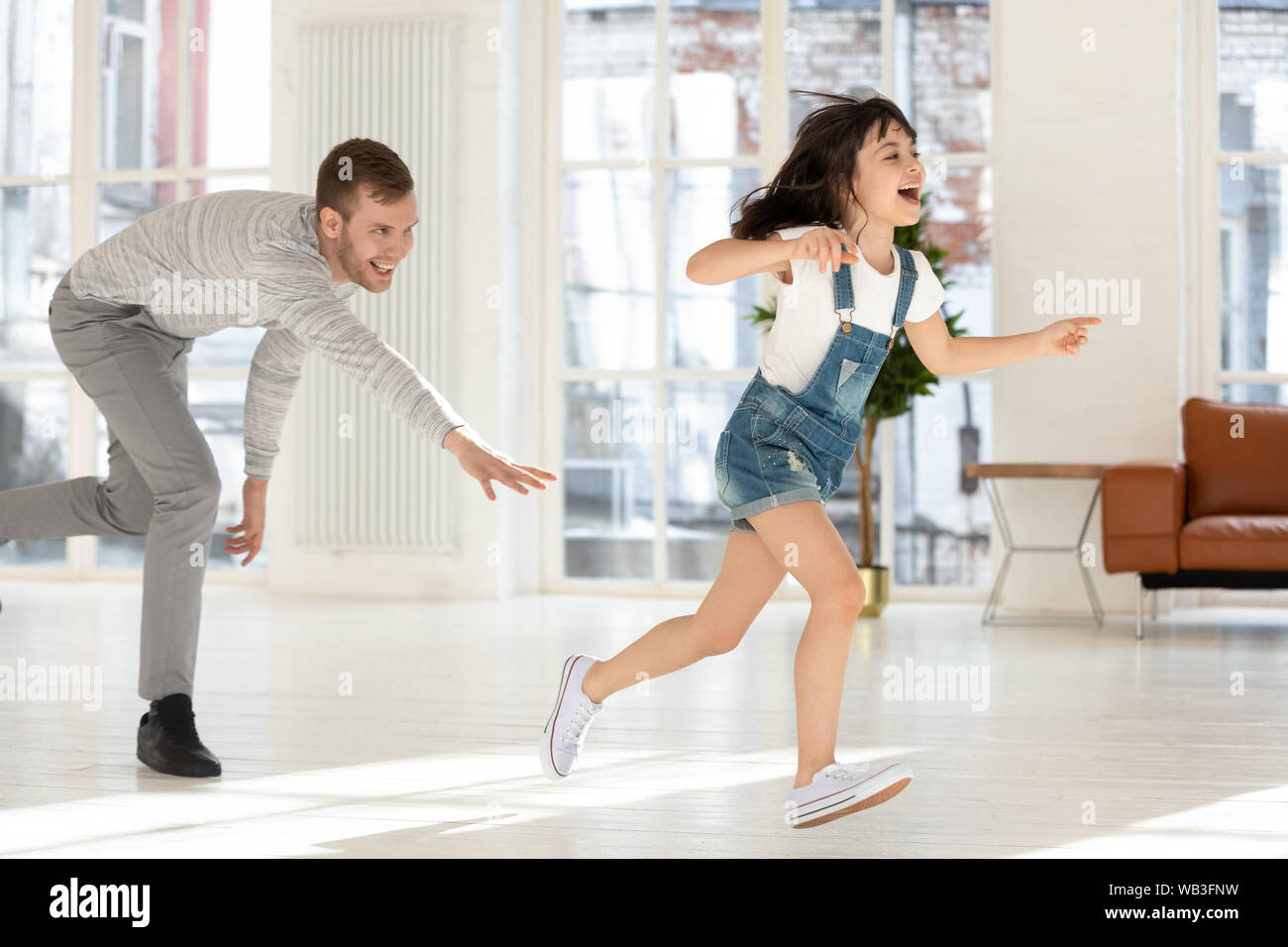 Carino bambino figlia in esecuzione da papà giocando Tag gioco insieme Foto Stock