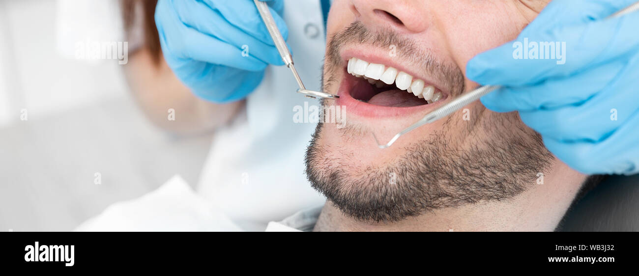 Giovane uomo dal dentista. Per le cure dentarie, avendo cura di denti. Immagine con copia spazio per lo sfondo. Foto Stock