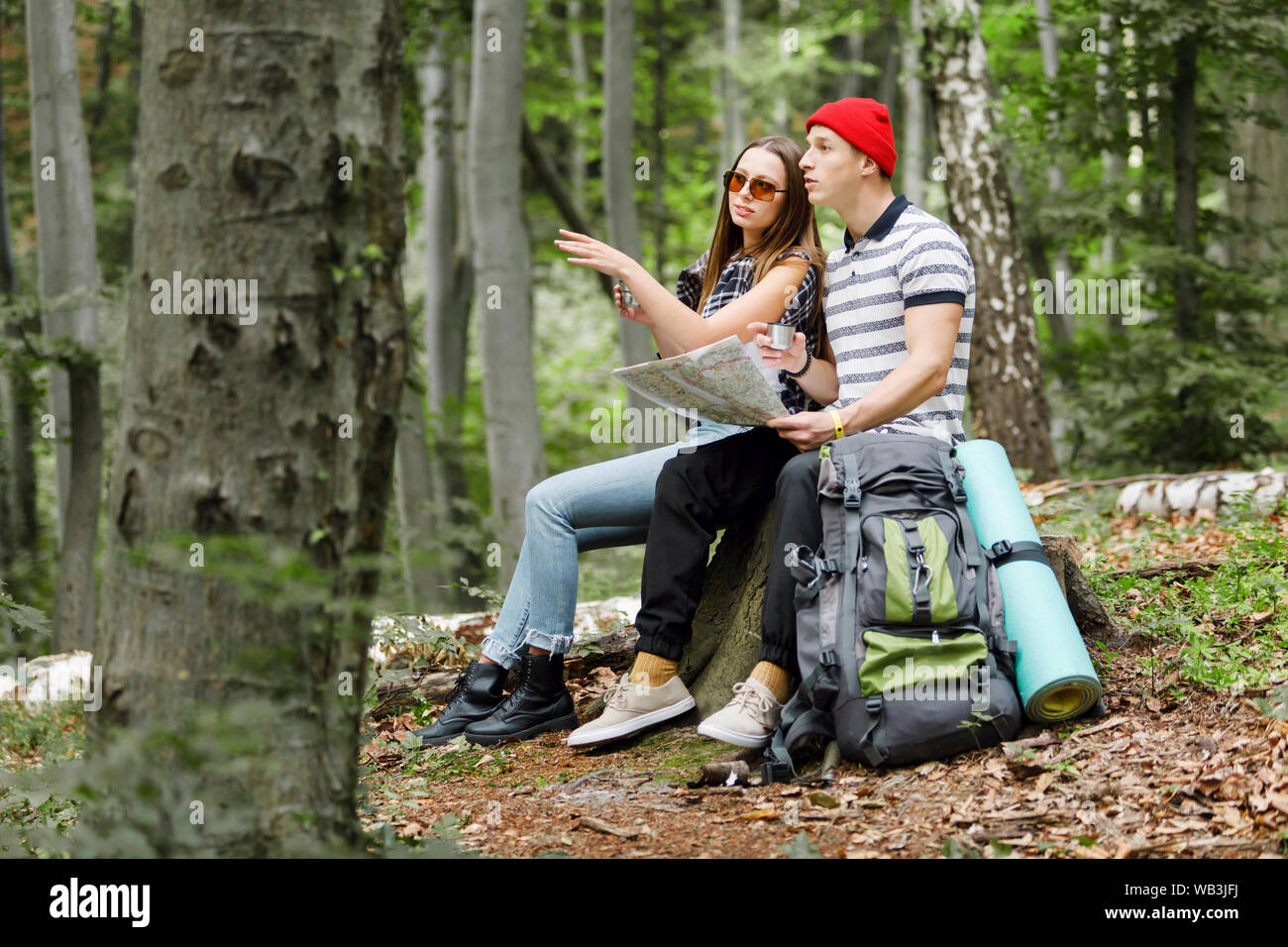 Paio di escursionisti alla ricerca direzione con una mappa mentre avente il freno in foresta Foto Stock