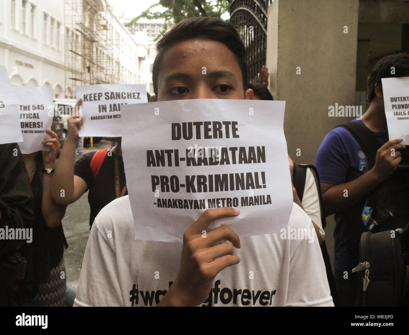 Manila, Filippine. 23 Ago, 2019. Un manifestante, detiene una targhetta dicendo "Duterte Administration è un protettore di criminali" di fronte al Dipartimento di Giustizia durante la dimostrazione.GABRIELA Alleanza delle Donne, insieme con le altre donne formazioni, terrà una manifestazione di protesta di fronte al Dipartimento di Giustizia a Manila per dimostrare la loro opposizione a qualsiasi movimento di rilasciare ex Calauan, Laguna sindaco Antonio Sanchez dalla prigione sotto RA 10592, una nuova legge che regola la buona condotta Indennità di tempo regola sotto la revisione del diritto penale. Credito: SOPA Immagini limitata/Alamy Live News Foto Stock