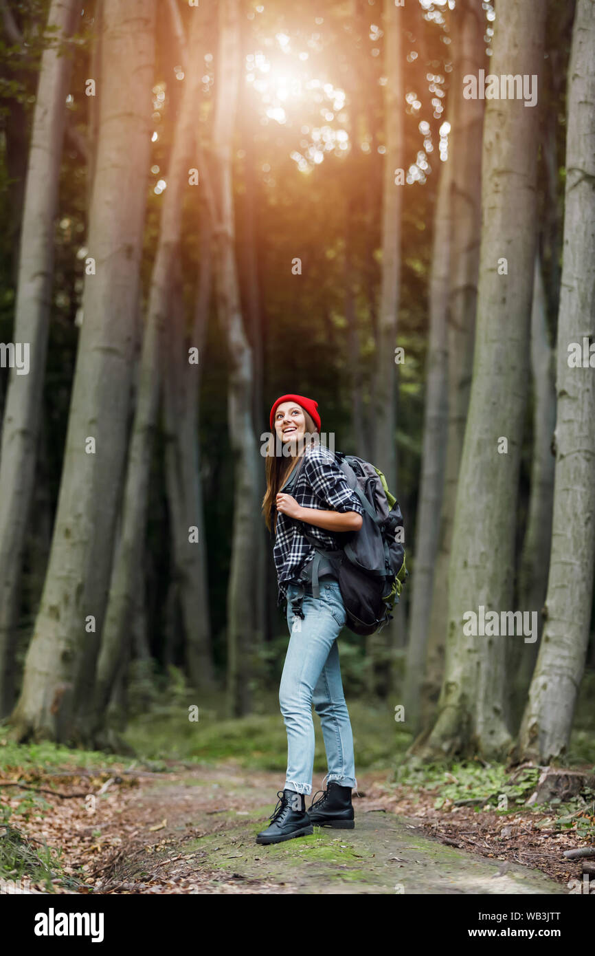 Elegante giovane donna con zaino cercando a incredibili boschi in estate, il concetto di viaggio Foto Stock