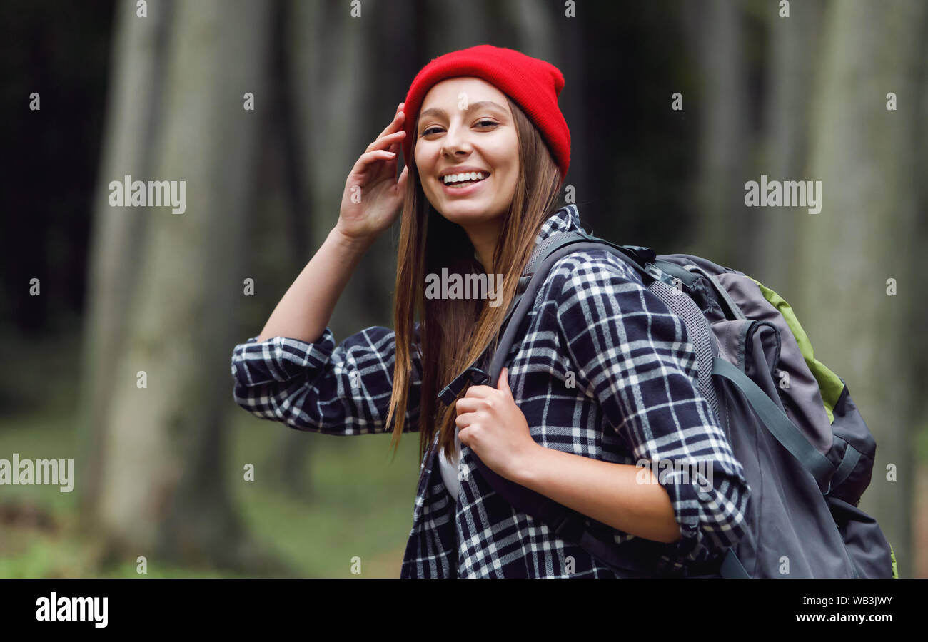 Donna di viaggio con felice espressione, gode di camminare nella natura, spende weekend nella foresta, ha tour escursioni da soli Foto Stock