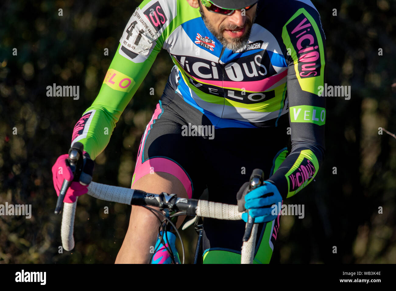 Il Ciclo-cross pilota in un vizioso velo colorato luminosamente jersey Foto Stock