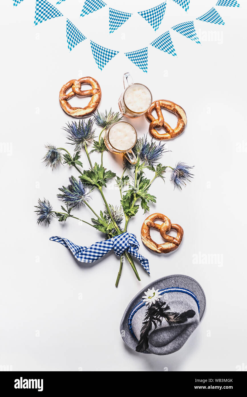 Oktoberfest composizione con tradizionali bavaresi bianco tessuto blu , decorazione, pretzel , bicchieri di birra bavarese, cappello e il mazzetto di alpine flowe Foto Stock