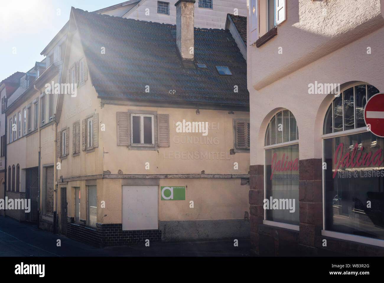 Bad Kissingen in Baviera, Germania - 16 Febbraio 2019: abbandonati piccolo negozio di generi alimentari con esfoliate pubblicità su weathered facciata - molto vecchio prelevati shop i Foto Stock