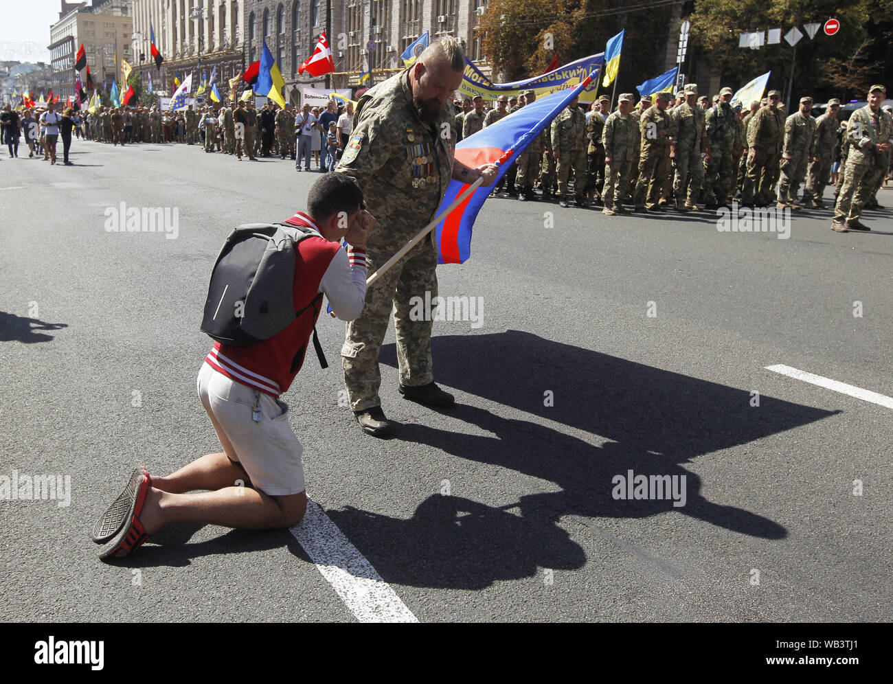 Kiev, Ucraina. 24 Ago, 2019. Un uomo si erge sulle sue ginocchia come egli dimostra il suo rispetto per Ukrainan combattenti che hanno partecipato in un conflitto militare in Ucraina orientale, durante il 'Marco di difensori dell'Ucraina" in occasione del Giorno di Indipendenza sulla piazza Indipendenza a Kiev, Ucraina, 24 agosto 2019. Gli ucraini contrassegnare il 28 anniversario dell'indipendenza dell'Ucraina dall'Unione Sovietica a partire dal 1991. Credito: Serg Glovny/ZUMA filo/Alamy Live News Foto Stock