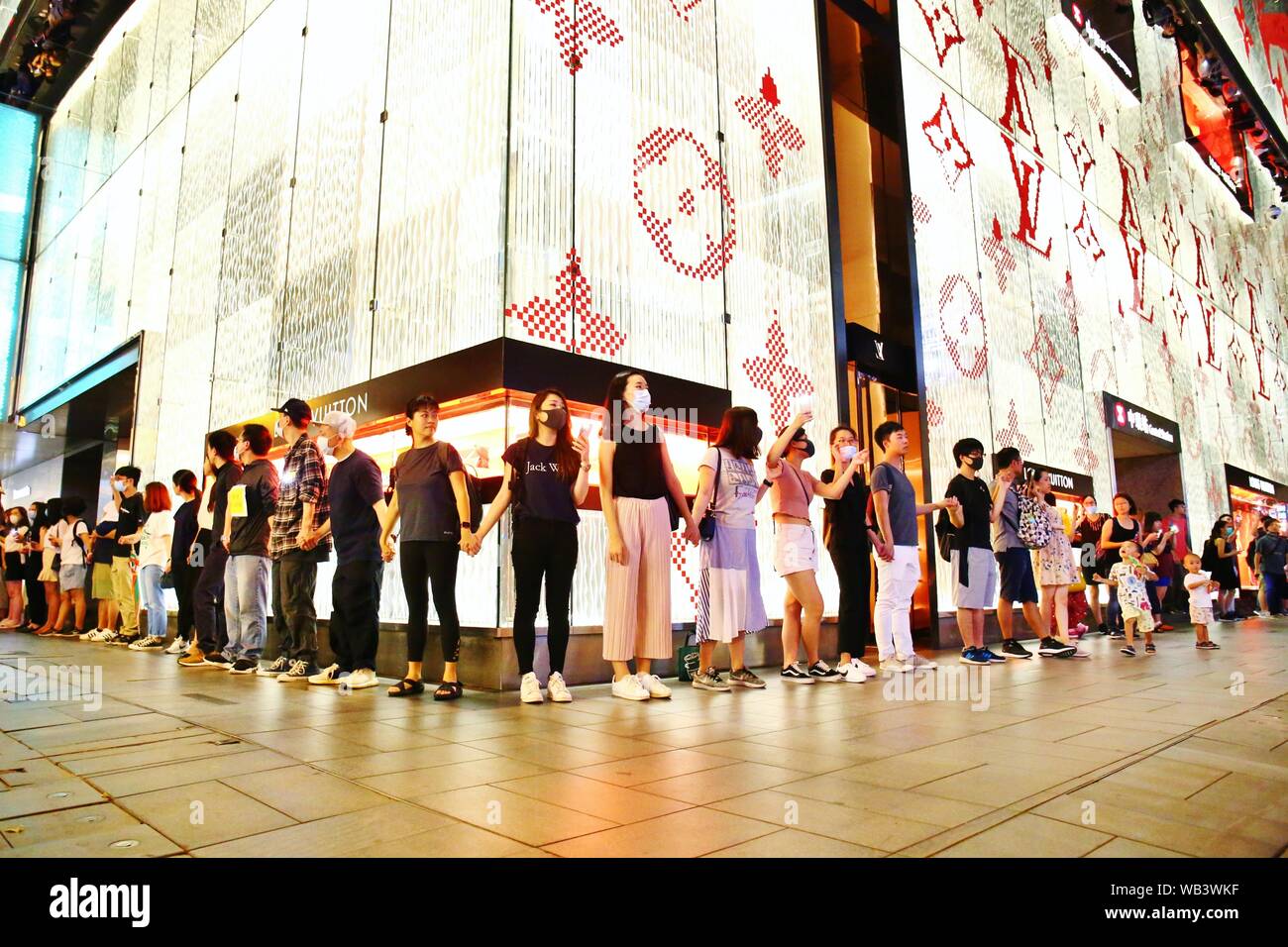 Hong Kong. 23 Ago, 2019. Più di 130.000 manifestanti formano una catena umana e unire le mani in vari distretti tra cui l'Isola di Hong Kong, Kowloon e i Nuovi Territori. La notte di venerdì che la protesta era ma non autorizzate e pacifici manifestanti visualizza banner, cantare canzoni per sollevare la consapevolezza internazionale della anti-movimenti di estradizione. Credito: Gonzales foto/Alamy Live News Foto Stock