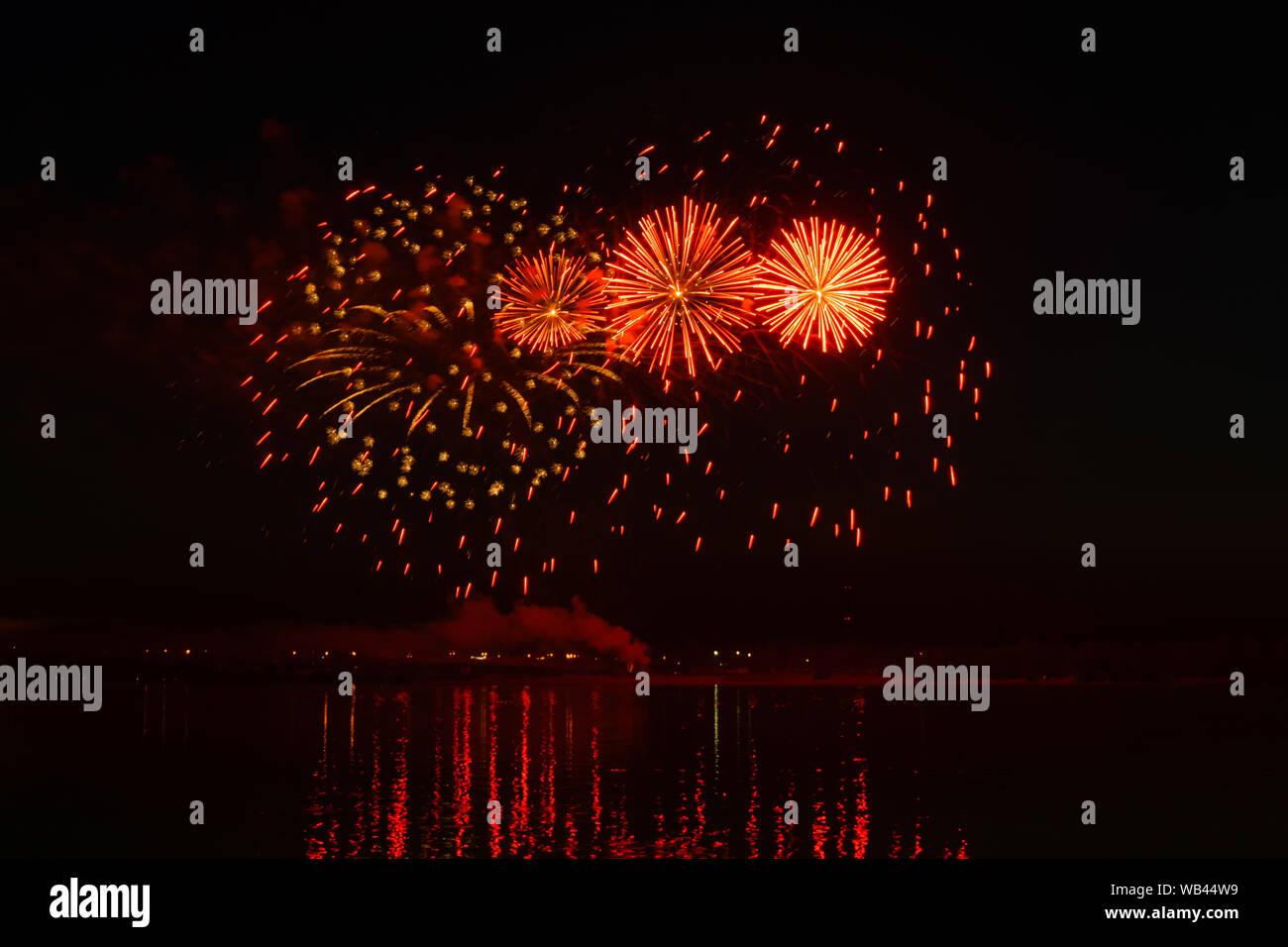 Lampeggia di festosi fuochi d'artificio sopra il fiume di notte si riflettono nell'acqua Foto Stock