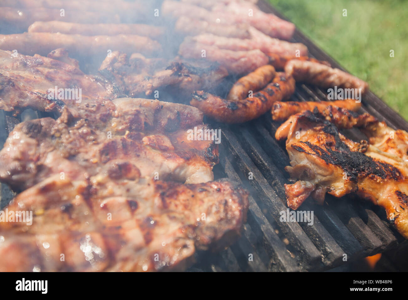 La preparazione di grigliate di carni miste su barbecue grill a carbone . Foto Stock