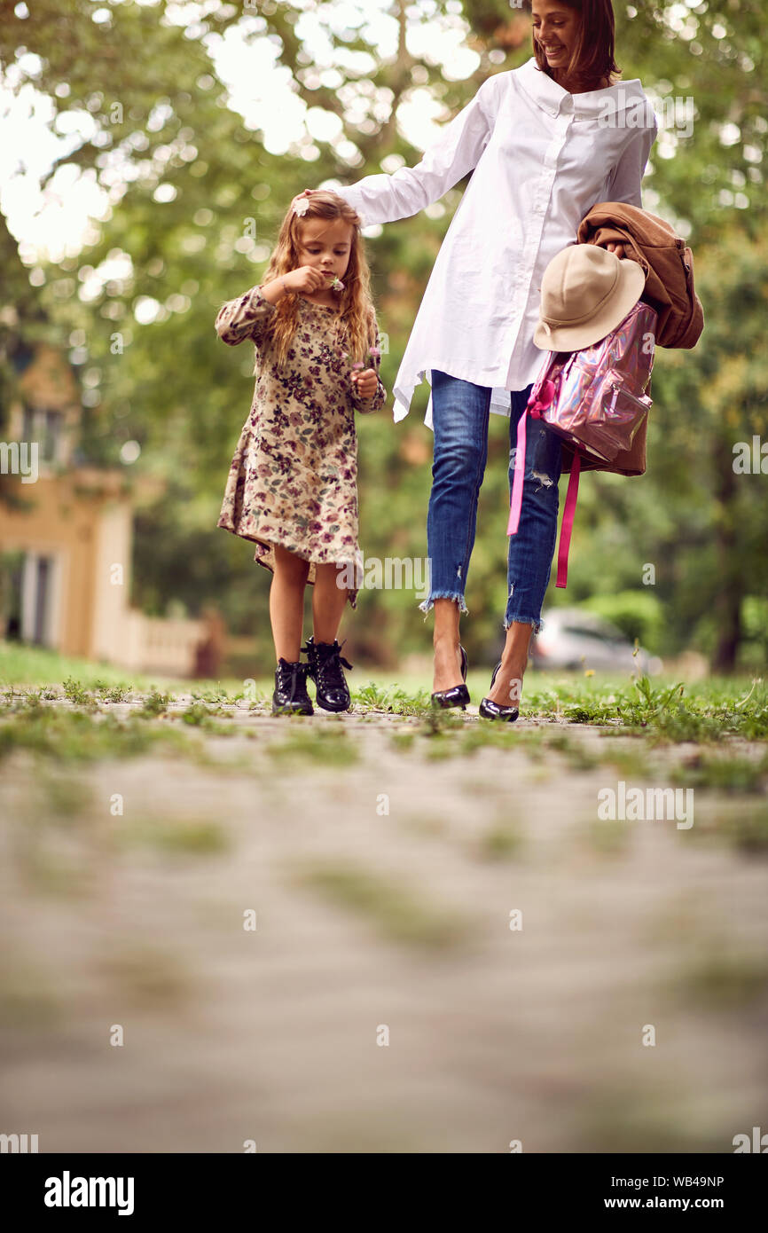 Madre e carina ragazza di scuola per andare a casa da scuola Foto Stock