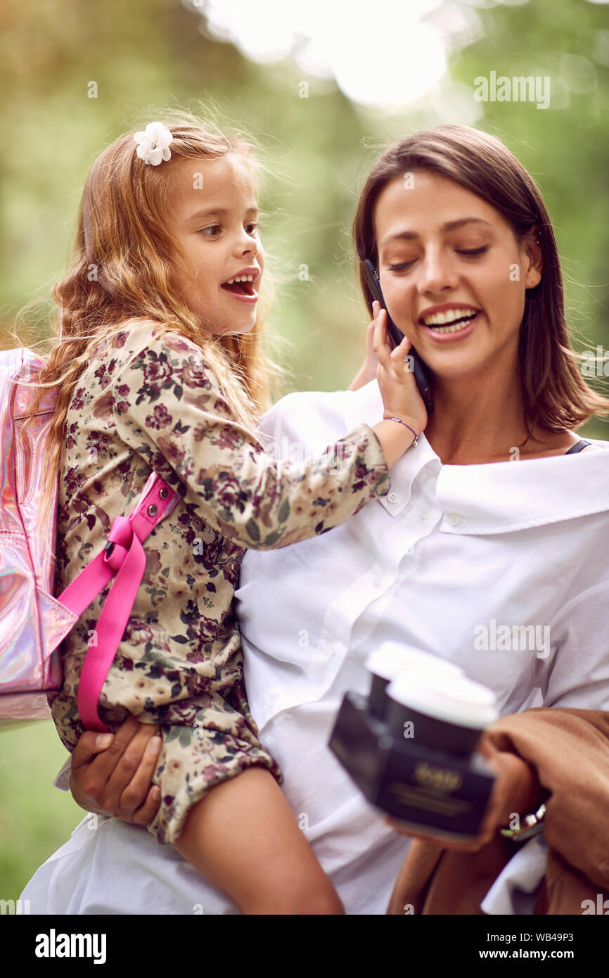 Happy business madre prendendo il bambino alla scuola primaria. Foto Stock