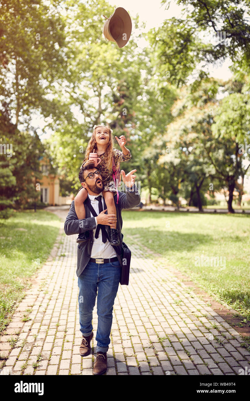 Padre Felice con la loro figlia dopo la scuola divertirsi Foto Stock