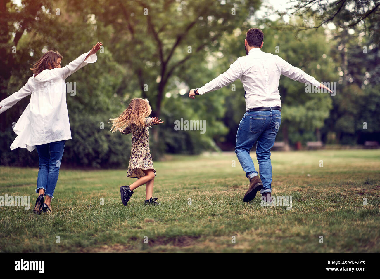 Felice genitore con il loro bambino ragazza dopo scuola nel parco giocando insieme Foto Stock