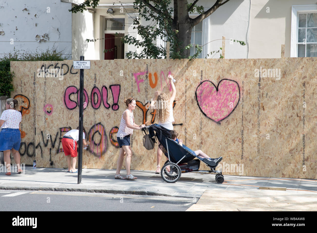 Le persone e le aziende start up di imbarco prima dell annuale carnevale di Notting Hill. Il legno diventa colorato con Graffitti. Foto Stock