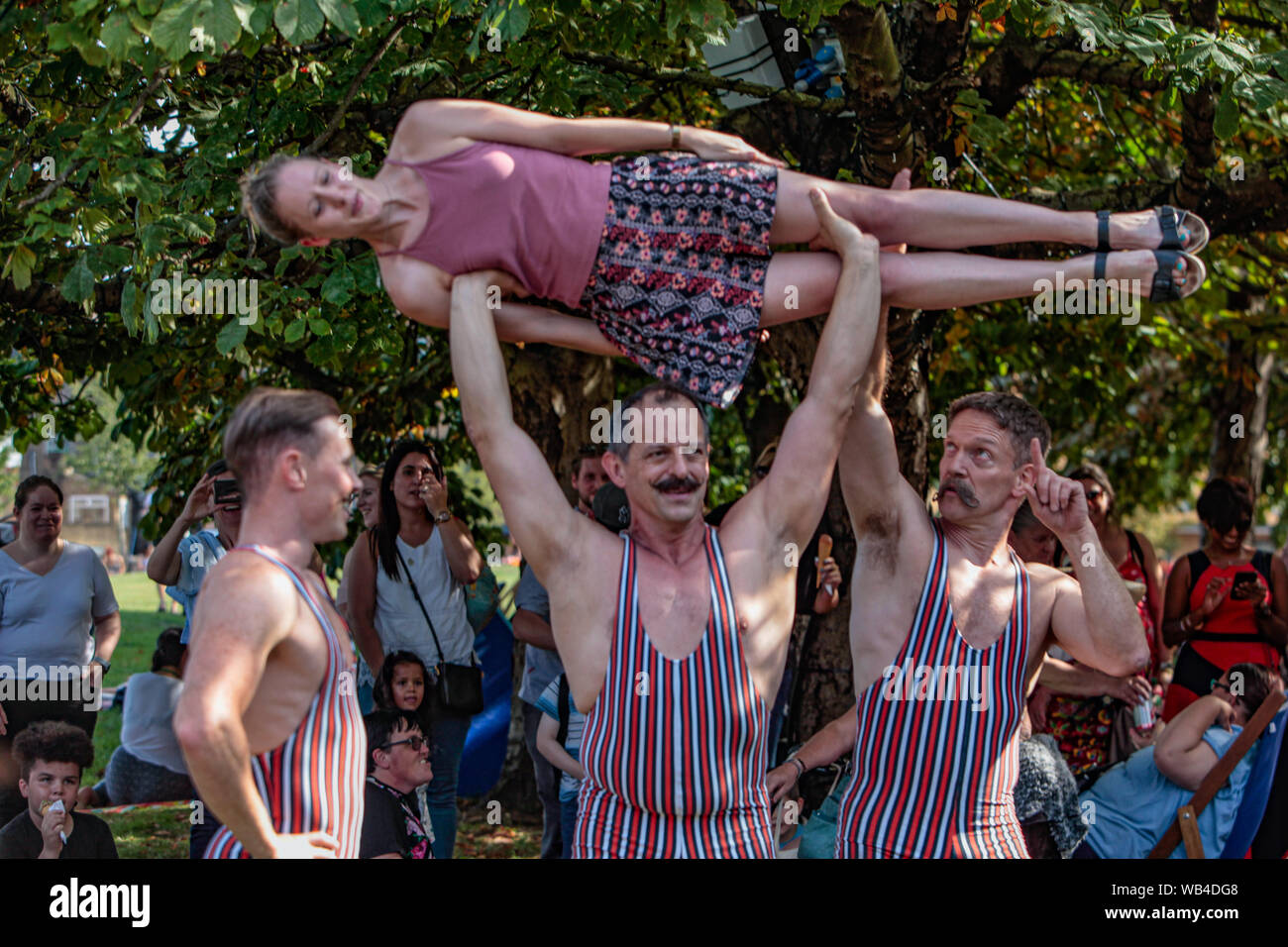 Londra, Regno Unito. 24 Ago, 2019. Vauxhall Pleasure Gardens sono stati presi indietro nel tempo per l'esperienza di stile vittoriano, questo piccolo angolo di sud di Londra è stato trasformato in stile vittoriano di un parco divertimenti a tema, con vivace e divertente, curioso circus interpreti e musica portando spettacoli Vittoriana alla vita di tutta la giornata. Lungo con funamboli, uomini forti, music hall bande, trampolieri il signor e la signora Flora sono interamente costume in profumi di fiori di seta.Paolo Quezada-Neiman/Alamy Live News Credito: Paolo Quezada-Neiman/Alamy Live News Foto Stock