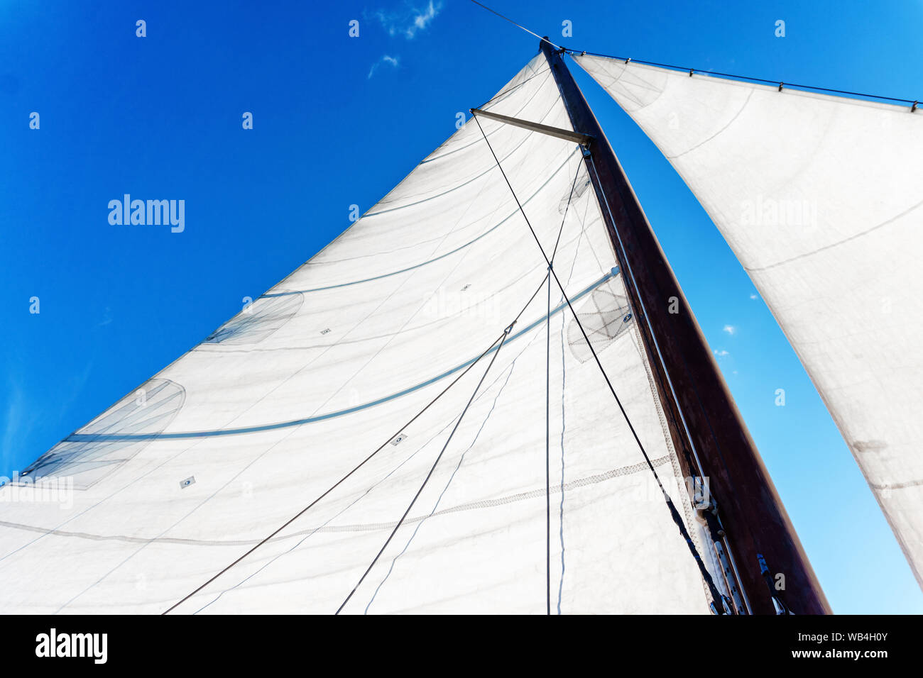 Montante di sollevamento di una barca a vela con vela bermuda apparecchiatura contro un cielo blu, bottom-up visualizza Foto Stock