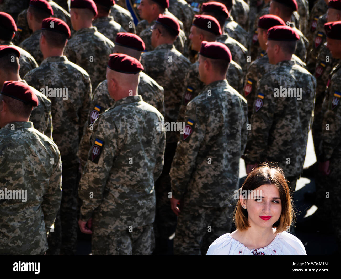 Giornalista TV reporting live con il personale militare in background, durante le celebrazioni.Il Presidente Vladimir Zelensky, leader dello stato, militare APU, volontari, atleti, prominente ucraini e altri hanno preso parte alla processione della dignità dedicata al ventottesimo anniversario del giorno dell'indipendenza dell'Ucraina tenutasi a Kiev. Foto Stock