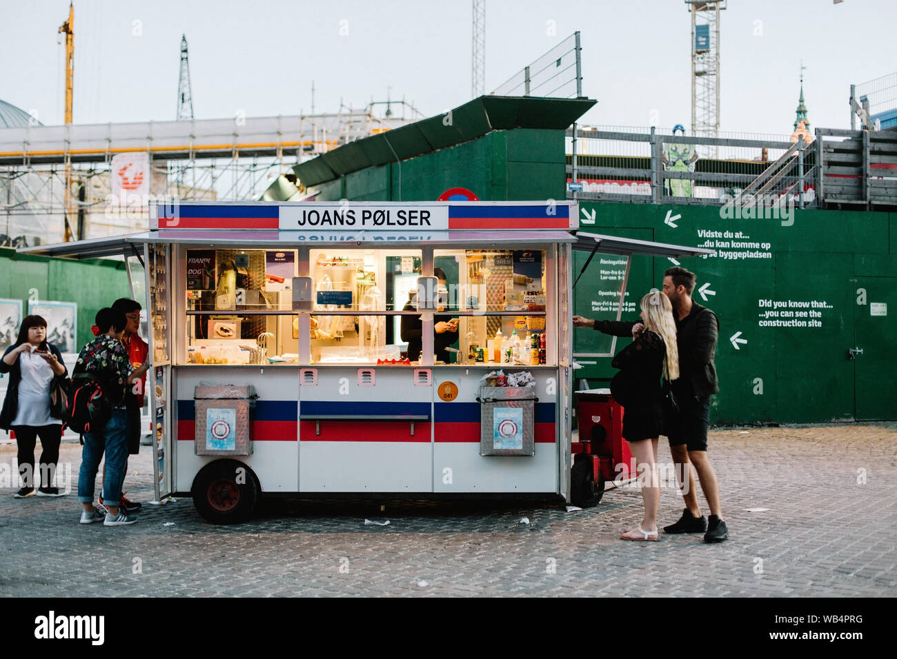 Copenaghen, Danimarca - Luglio 21st, 2016: ordinazione di popolo danese tradizionale cani a caldo da un carrello in una serata estiva nel centro cittadino. Foto Stock
