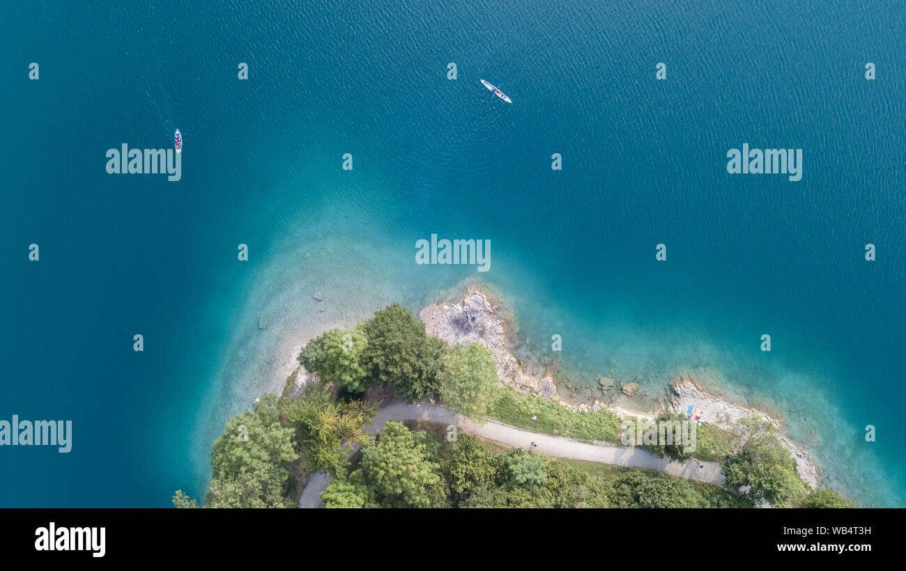 In alto e in basso del drone vista aerea del Lago di Ledro. Un naturale lago alpino. Incredibile turchese, il verde e il blu i colori naturali. Alpi italiane. L'Italia. Tourist Foto Stock