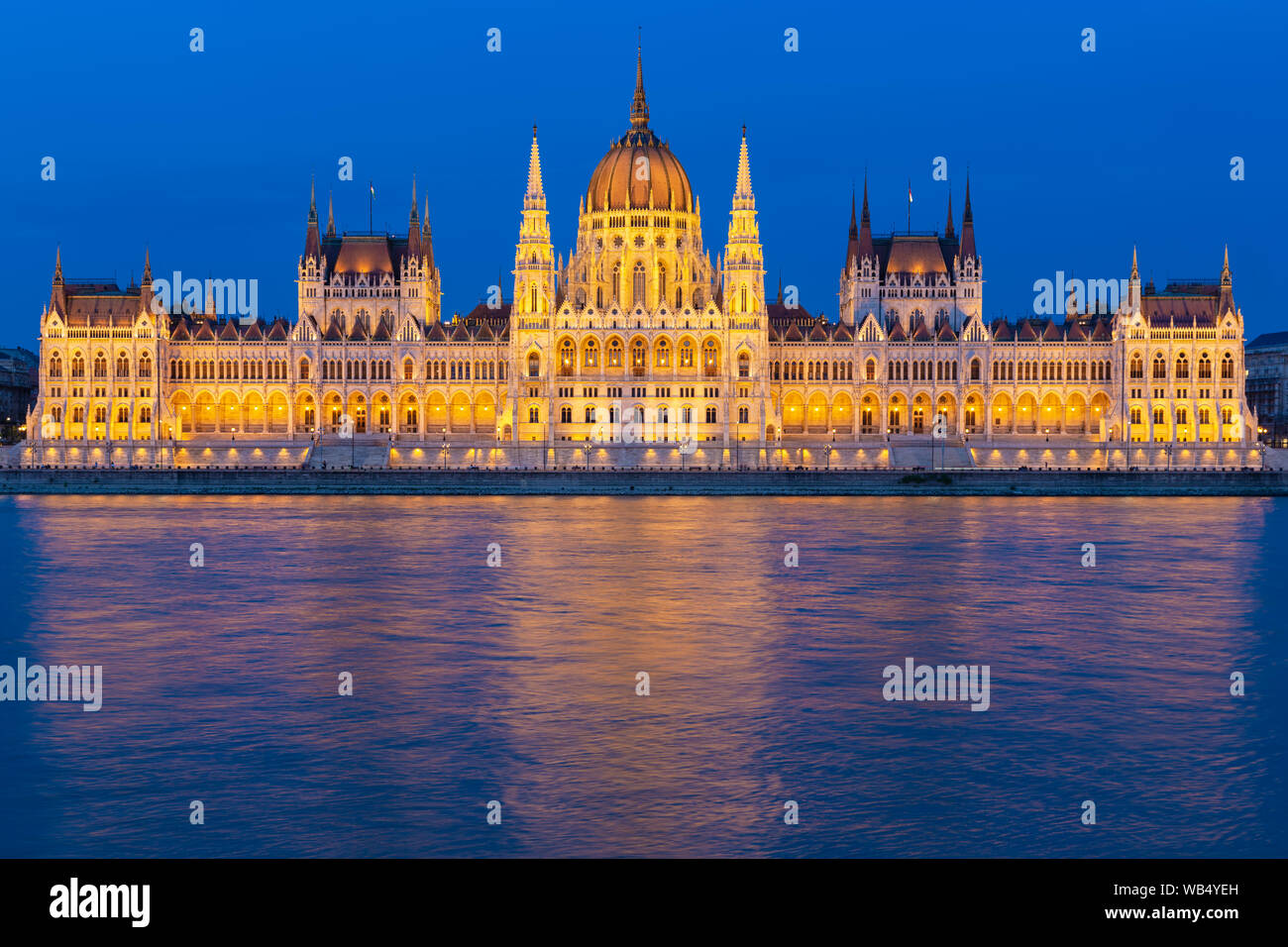 Il Palazzo del Parlamento lungo il fiume Danubio di notte Foto Stock