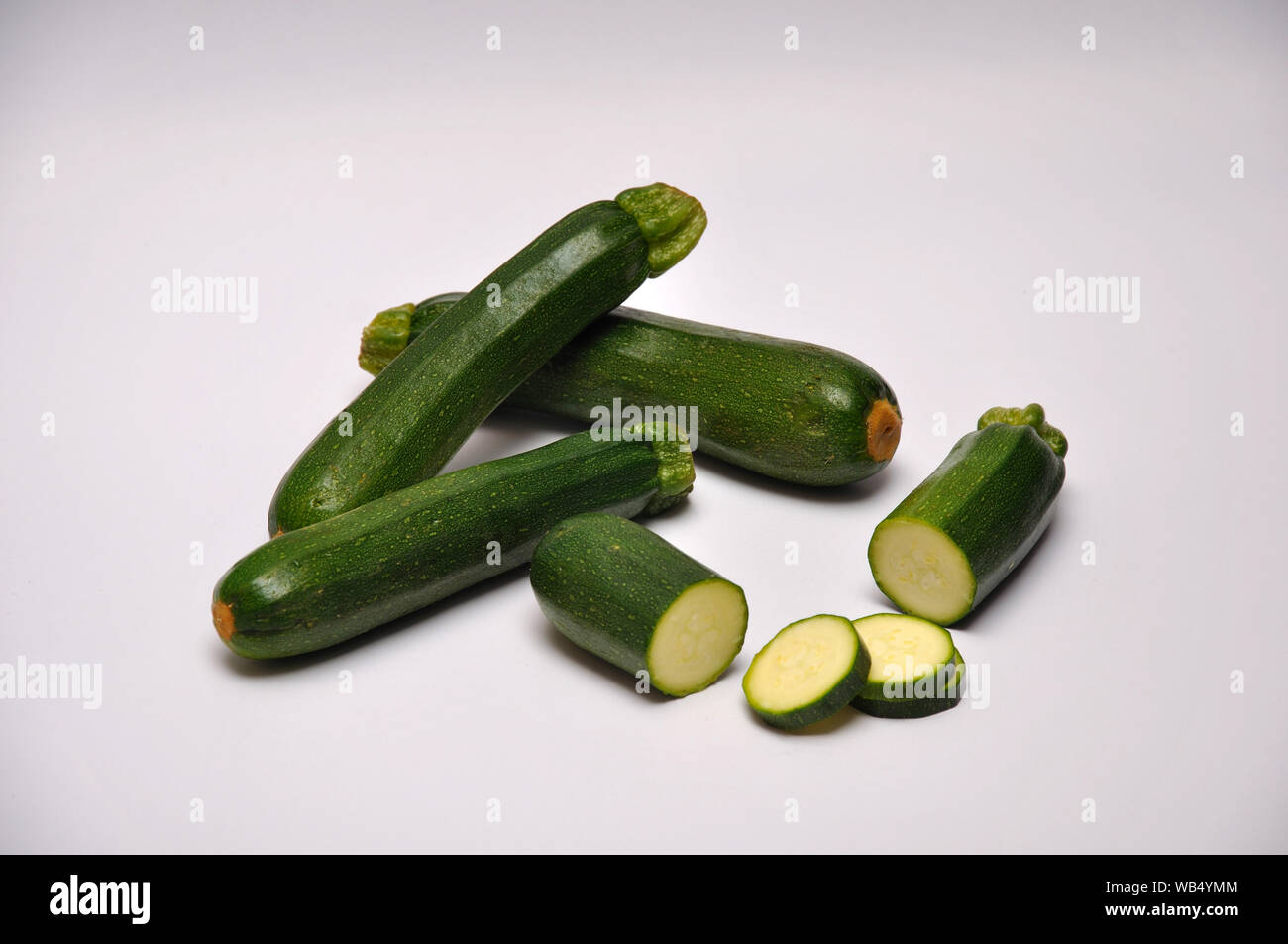 Intero e fette di zucchine su un sfondo senza giunture Foto Stock