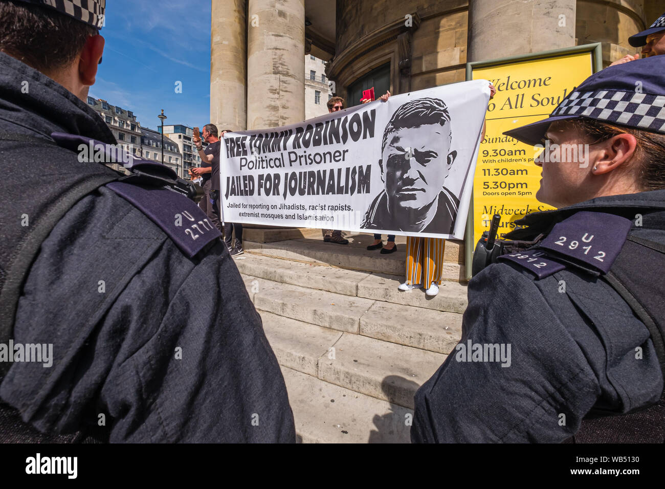 Londra, Regno Unito. 24 Ago, 2019. La polizia di proteggere la protesta presso la BBC da Tommy Robinson sostenitori che affermano che egli è in carcere per il giornalismo. Egli è stato condannato a 9 mesi per 3 reati al di fuori di Leeds Crown Court che potrebbe aver causato il crollo di una toelettatura pista di prova e ha precedenti condanne per violenza, finanziari e frodi in materia di immigrazione, del possesso di droga e di ordine pubblico reati. La polizia ha mantenuto la due gruppi separati. Robinson sostenitori sono stati successivamente unite dai dimostranti da Trafalgar Square, e un gruppo di grandi dimensioni dal supporto fino al razzismo è venuto per unire Antifa. Credito: Peter Marshall / Alamy Live News Foto Stock
