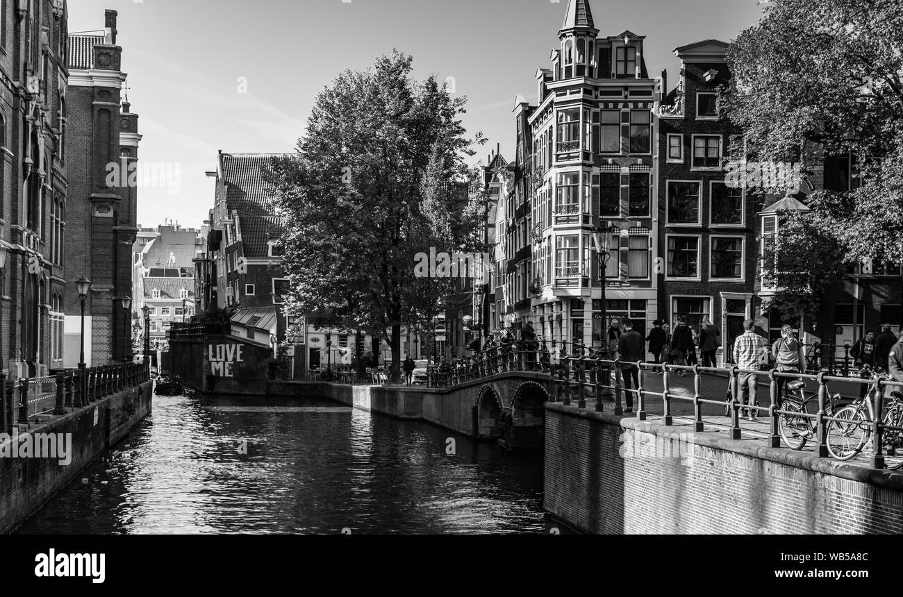 In bianco e nero vista sul cannal Grimburgwal a ponte con il segno love me. Oudezijds Voorburgwal, Grimnessesluis Foto Stock