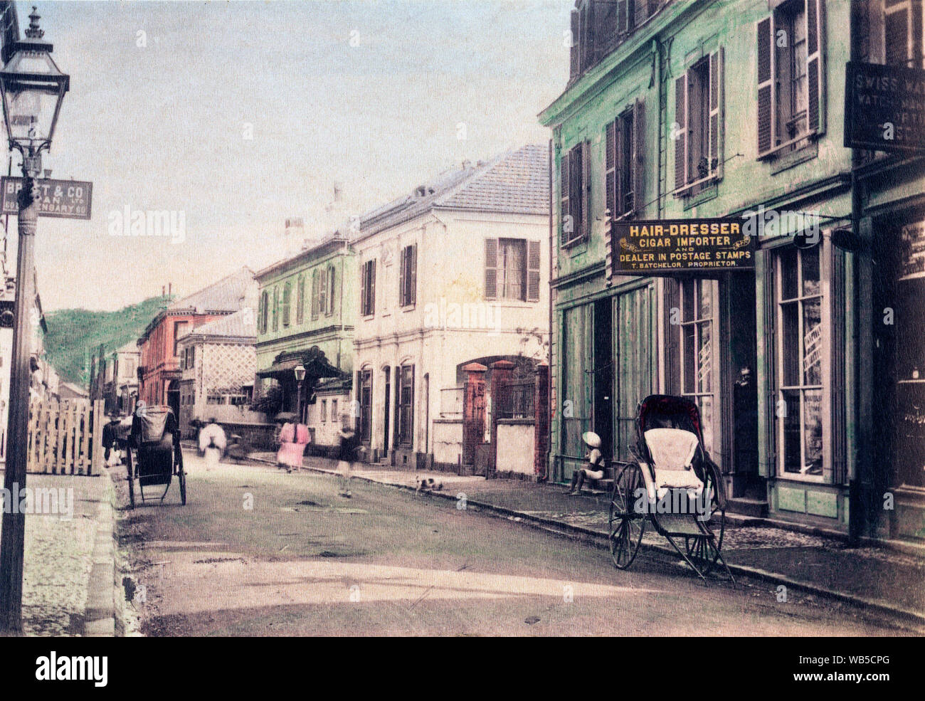 [ 1890 Giappone - Main Street a Yokohama ] - Negozi in Honcho-dori a Yokohama, nella prefettura di Kanagawa. Il fotografo si fermò vicino a n. 60 dove Maebashi-cho interseca con Honcho-dori. Lanterne a gas la linea street. Sulla destra un rickshaw è parcheggiato di fronte alla creazione di proprietà di T. laurea, che curiosamente è un parrucchiere, un sigaro importatore e rivenditore in francobolli. Xix secolo albume vintage fotografia. Foto Stock