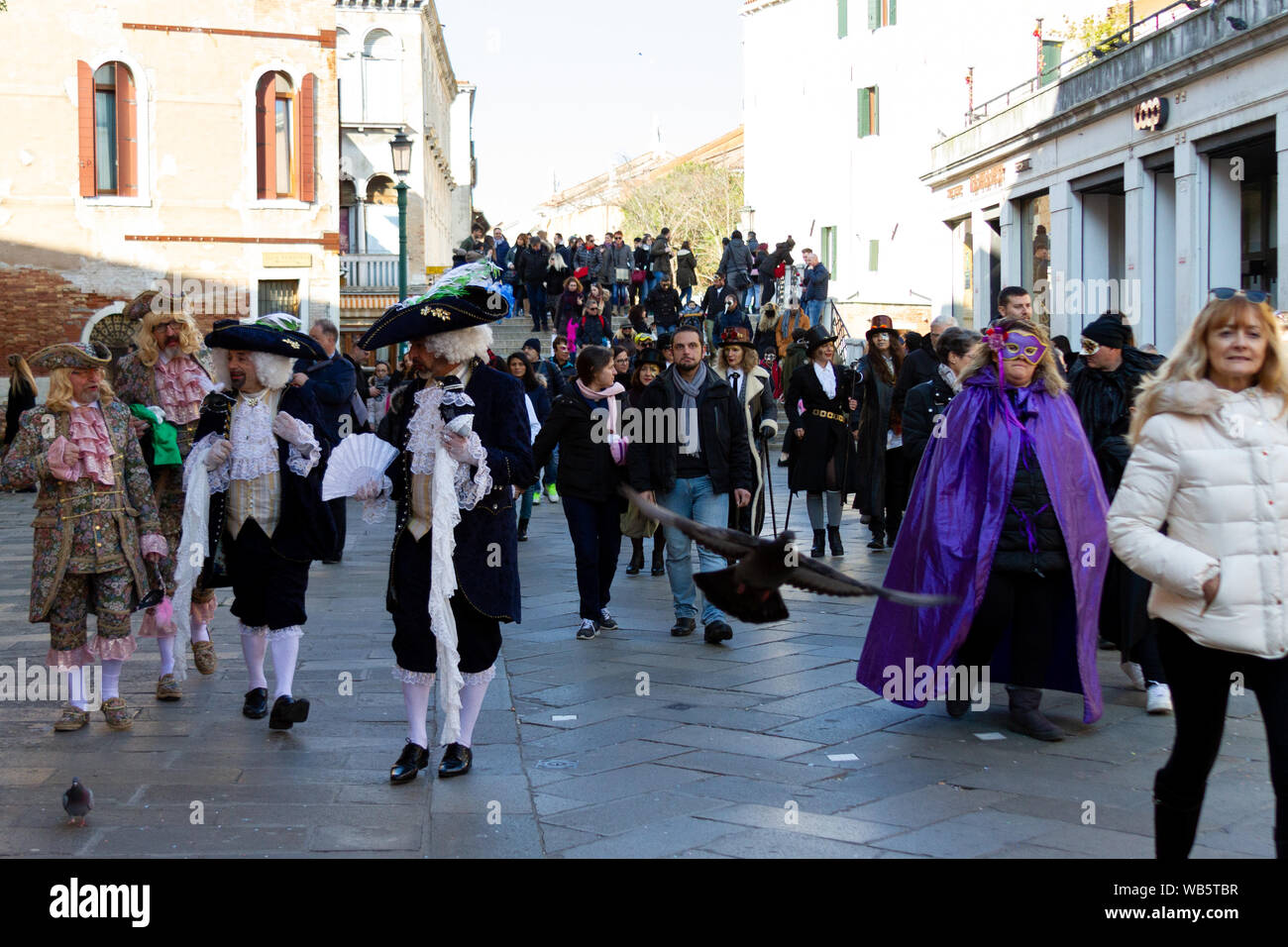 Una strada affollata di Venezia durante il carnevale, alcune persone sono in maschere. Foto Stock