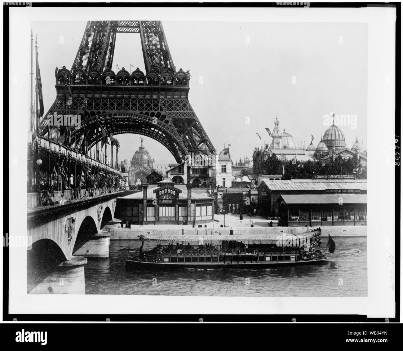Mostra gli edifici e la base della torre Eiffel come si vede dal Fiume Senna, con bateau mouche in primo piano, Esposizione di Parigi, 1889 Abstract/medio: 1 carte da stampa fotografiche : albume. Foto Stock