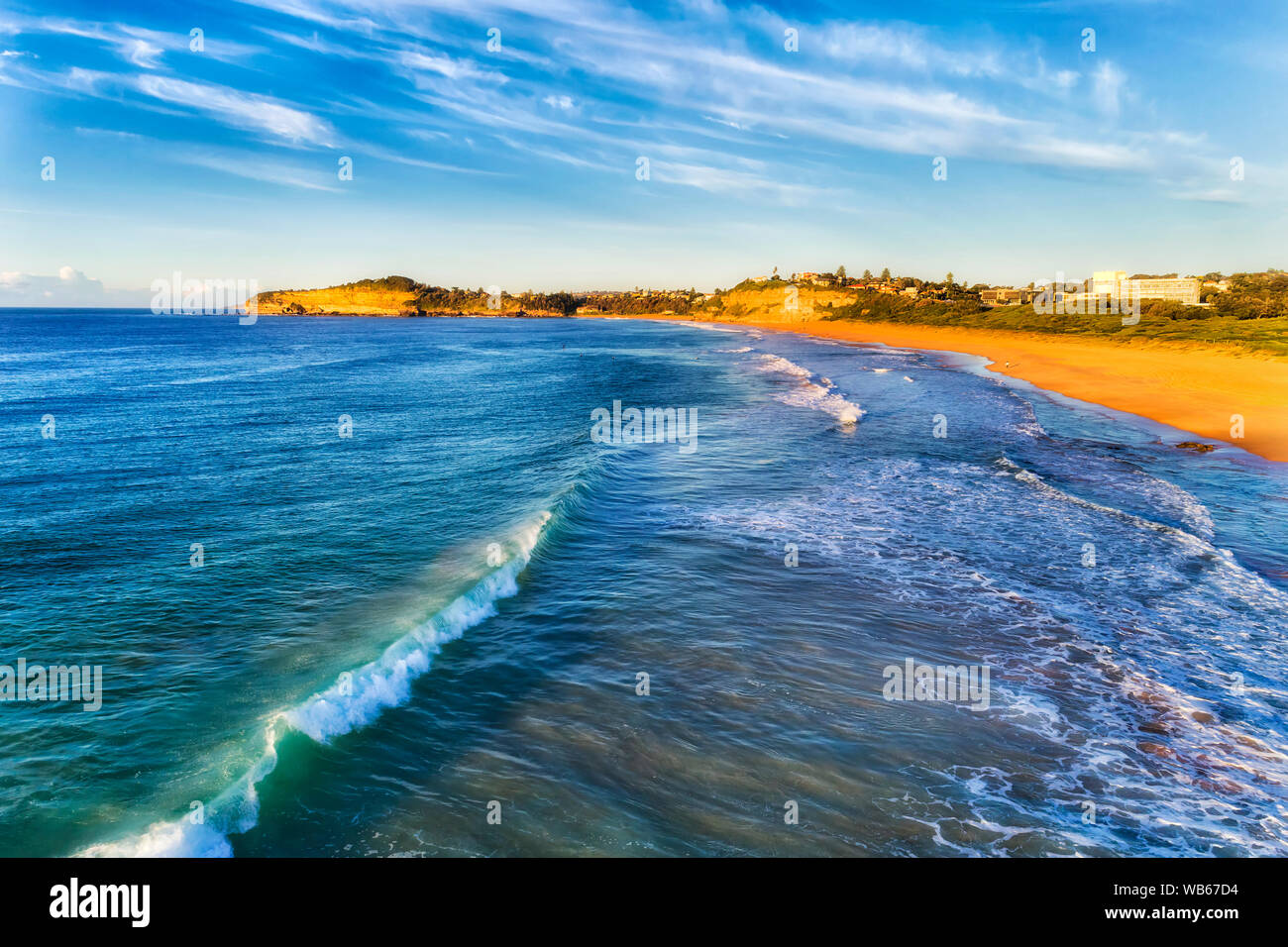 Le onde di laminazione a Mona Vale beach - ottimo posto per la scheda navigazione sul nord di Sydney in morbida luce mattutina visto da sopra verso la riva sabbiosa Foto Stock