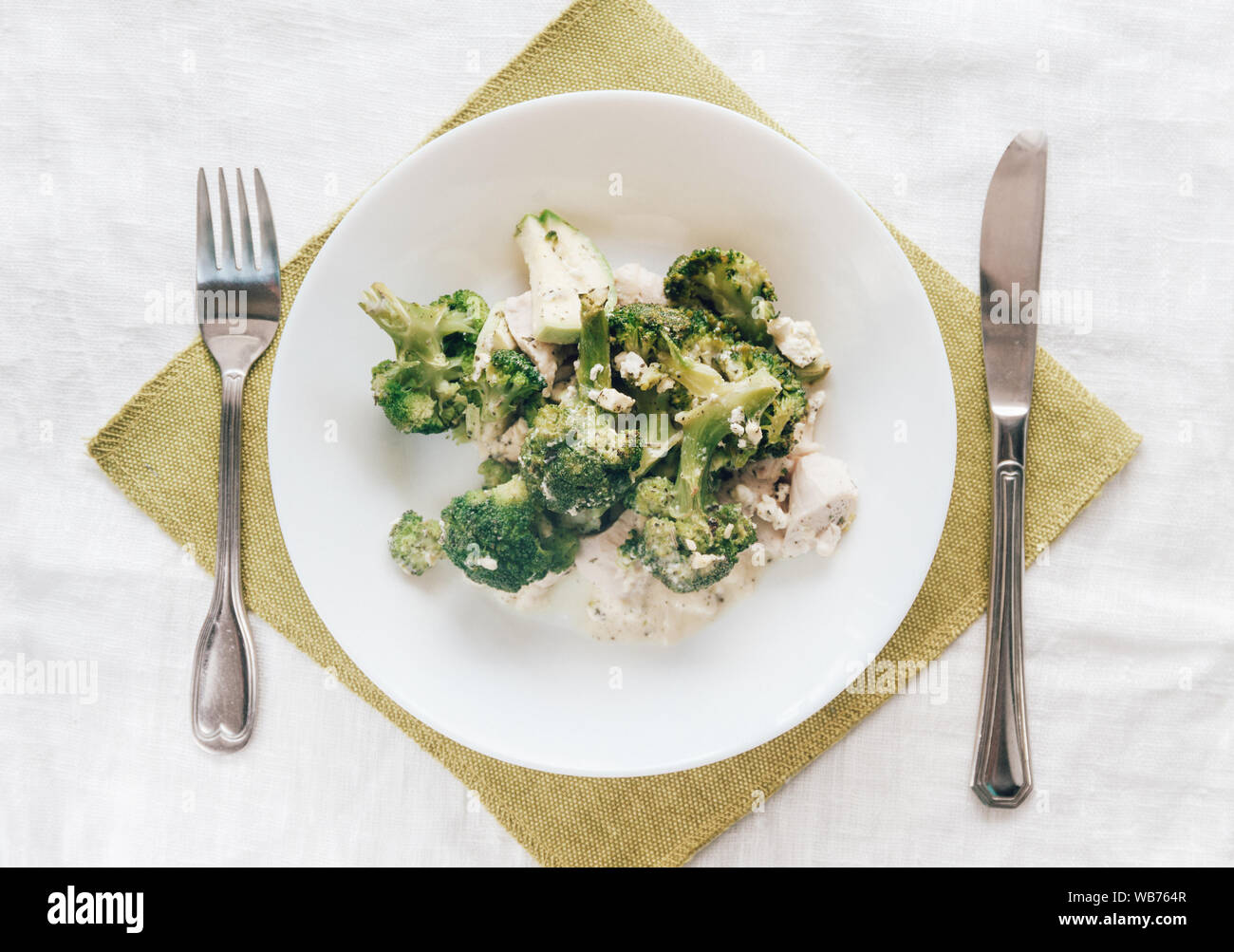 Broccoli cotti al forno con pollo su una piastra bianca. Vista superiore, close-up. Una sana e corretta alimentazione. Foto Stock