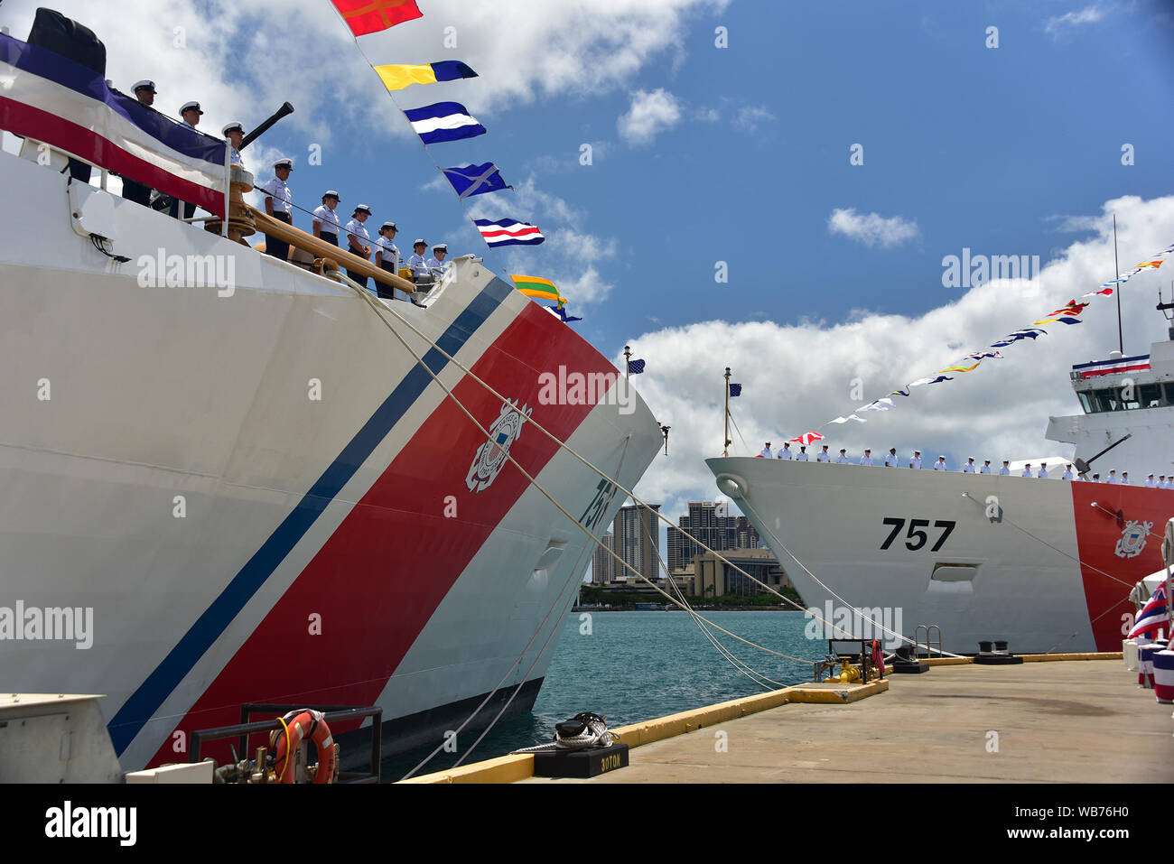 Il suo equipaggio da Guardacoste Kimball WMSL (756), il primo piano e Guardacoste Midgett WMSL (757) linea le rotaie per "portare le navi a vita" durante una doppia unica cerimonia di messa in servizio per i coltelli di taglio in corrispondenza della Guardia Costiera Honolulu Base 24 agosto 2019. Le navi sono la settima e ottava posizione legenda classe di sicurezza nazionale taglierine commissionata dalla Guardia Costiera e le prime due homeported nelle Hawaii. (U.S. Coast Guard foto di Chief Petty Officer John Masson/rilasciato) Foto Stock