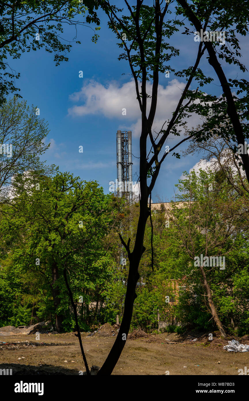 Fumo camino industriale contro il cielo blu con nuvole bianche. Foto Stock