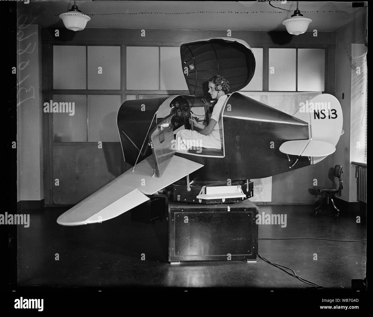 Galleggianti attraverso l'aria. Washington, D.C. Agosto 6. I link trainer per non vedenti battenti presso il dipartimento di commercio prende i piloti Su cross- paese viaggi ma mai lasciare l'edificio. Vola e gestisce come un aereo il prelievo di radio beacon sul corso, bancario e tornitura, non sapere se ha raggiunto la sua destinazione fino a quando egli non è thru con il volo. Mostra fotografica di Miss Eleanor Sterbis circa per tenere una lezione nel trainer Abstract/medio: 1, negativo : vetro ; 4 x 5 in. o più piccolo Foto Stock