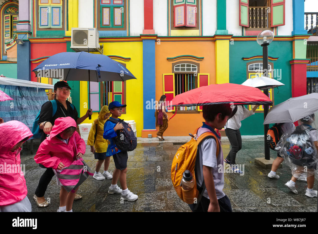 In caso di forte pioggia, scuola i bambini passano la casa di Tan Teng Niah, la coloratissima villa di un ex imprenditore cinese; Little India, Singapore Foto Stock