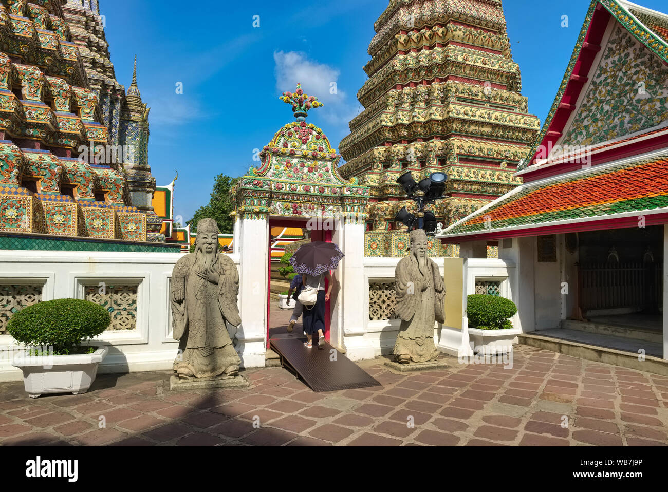 Chedis (stupa), cinese guardian figure e un tempio edificio in motivi di Wat Po (Pho), Bangkok, Thailandia, il Tempio del Buddha reclinato Foto Stock