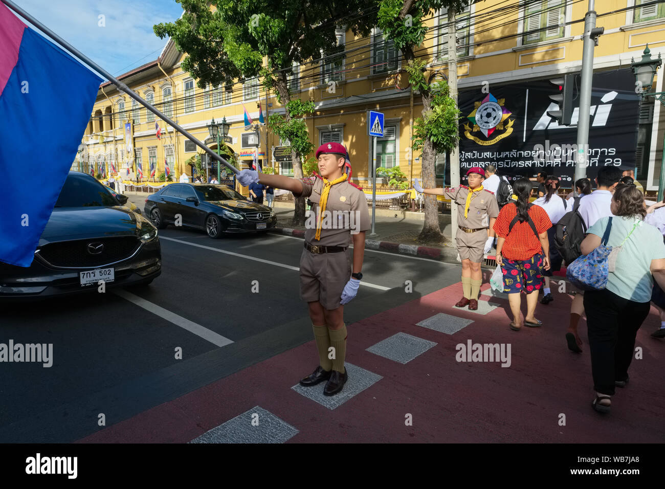 Due boy scout a guardia di una zebra crossing di fronte Suankularb (Suan Gularb) Wittayalai scuola, un patrimonio bldg. in area Pahurat, Bangkok, Thailandia Foto Stock