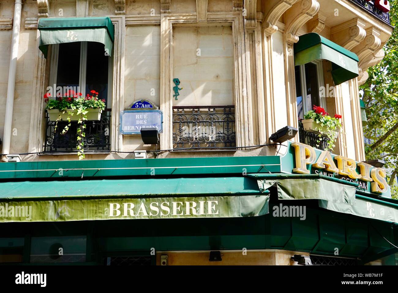 Segno di Parigi e piuttosto gerani in scatole di finestra su un angolo della brasserie, rue des Bernardins e Boulevard Saint Germain, Paris, Francia Foto Stock