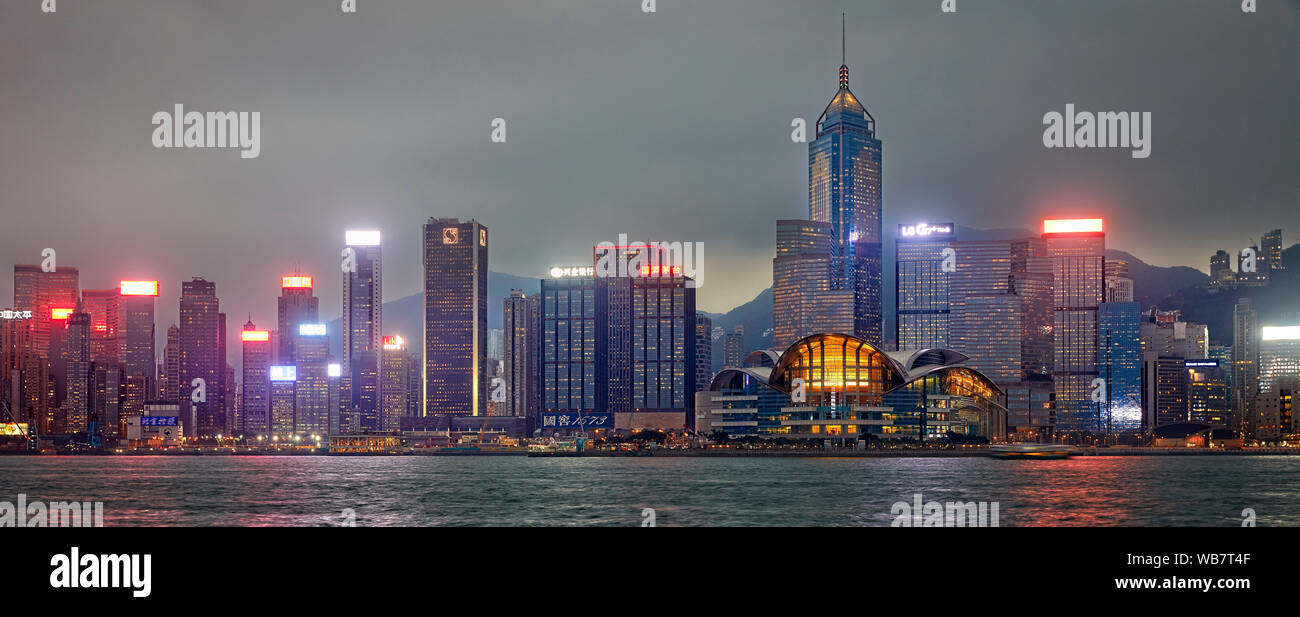 Skyline di Hong Kong illuminata al crepuscolo. Hong Kong, Cina. Foto Stock