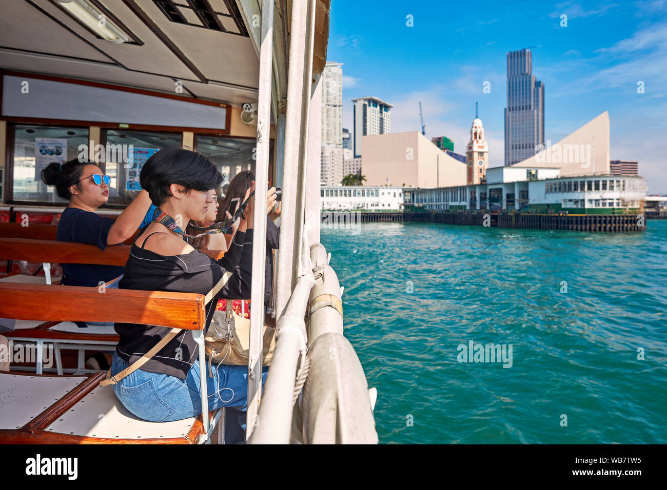 I turisti a scattare foto da Star Ferry boat in Victoria Harbour. Hong Kong, Cina. Foto Stock