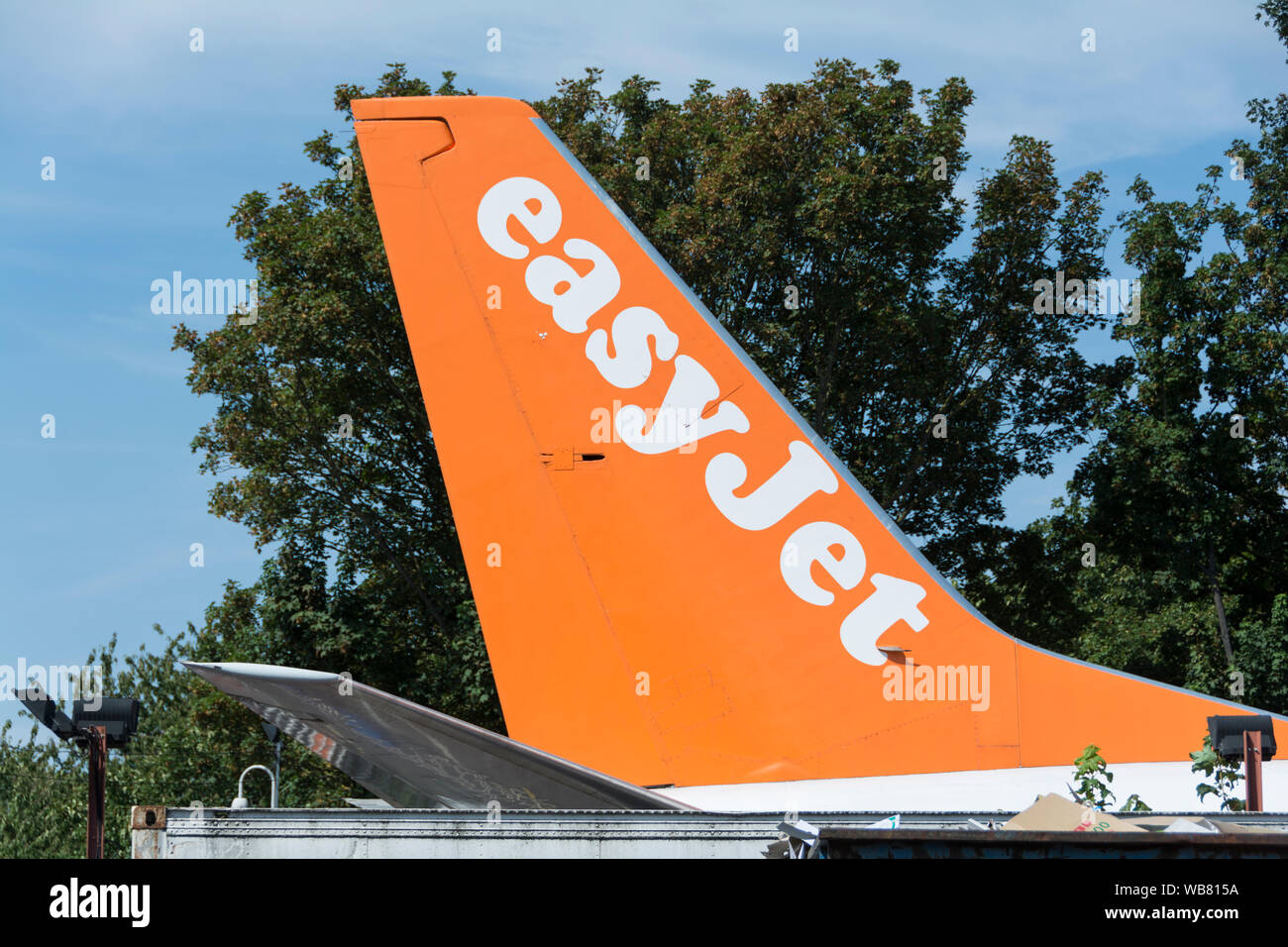 Close-up di un piano easyJet pinna di coda al di fuori del easyFood e easyBus store sulla North Circular Road, London, NW10, Regno Unito Foto Stock