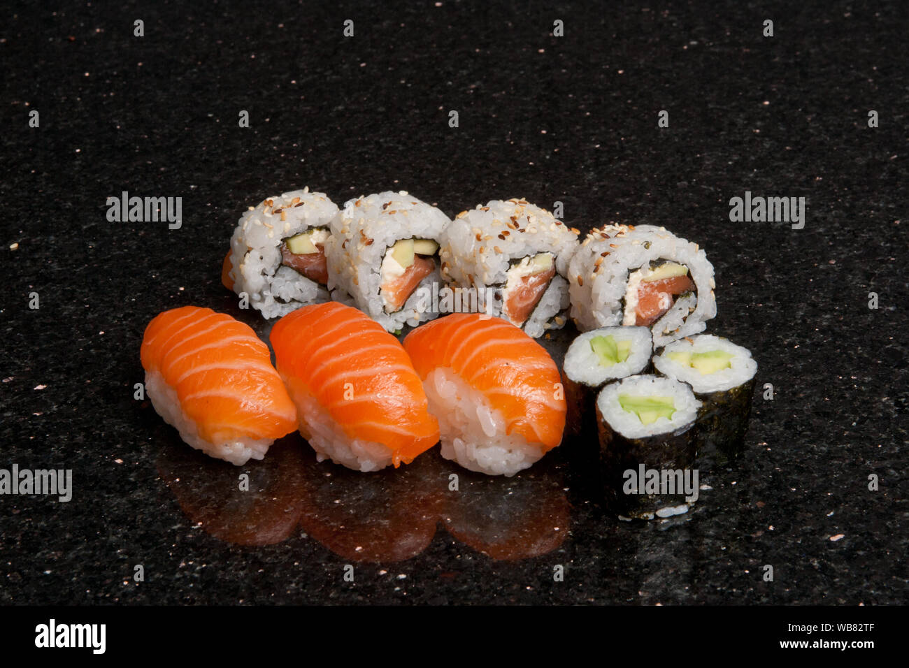 Rotoli di sushi su marmo nero lo sfondo. Hosomak freschi, maki e nigiri,  tempura, Uramaki, Philadelphia pezzi con riso, nori e pesce. Cucina  Giapponese Foto stock - Alamy