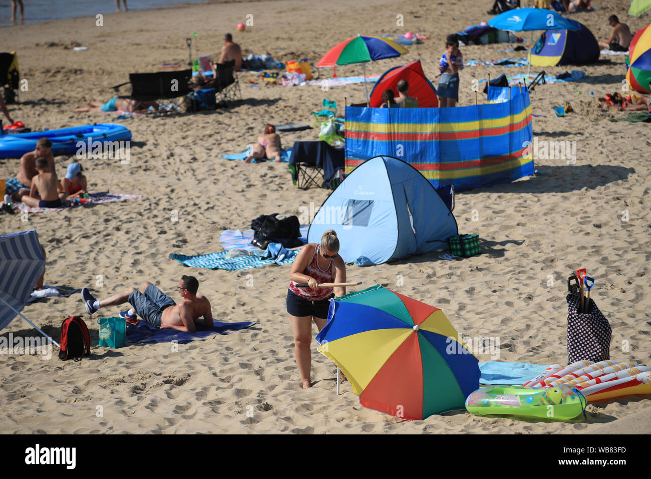 La gente sulla spiaggia di Bournemouth godetevi il sole che è impostata su continua per tutto il fine settimana lungo, anche con le temperature più calde previsto ed eventualmente raggiungere un record di 33C, più probabilmente nel sud-est dell'Inghilterra, il lunedì. Foto Stock