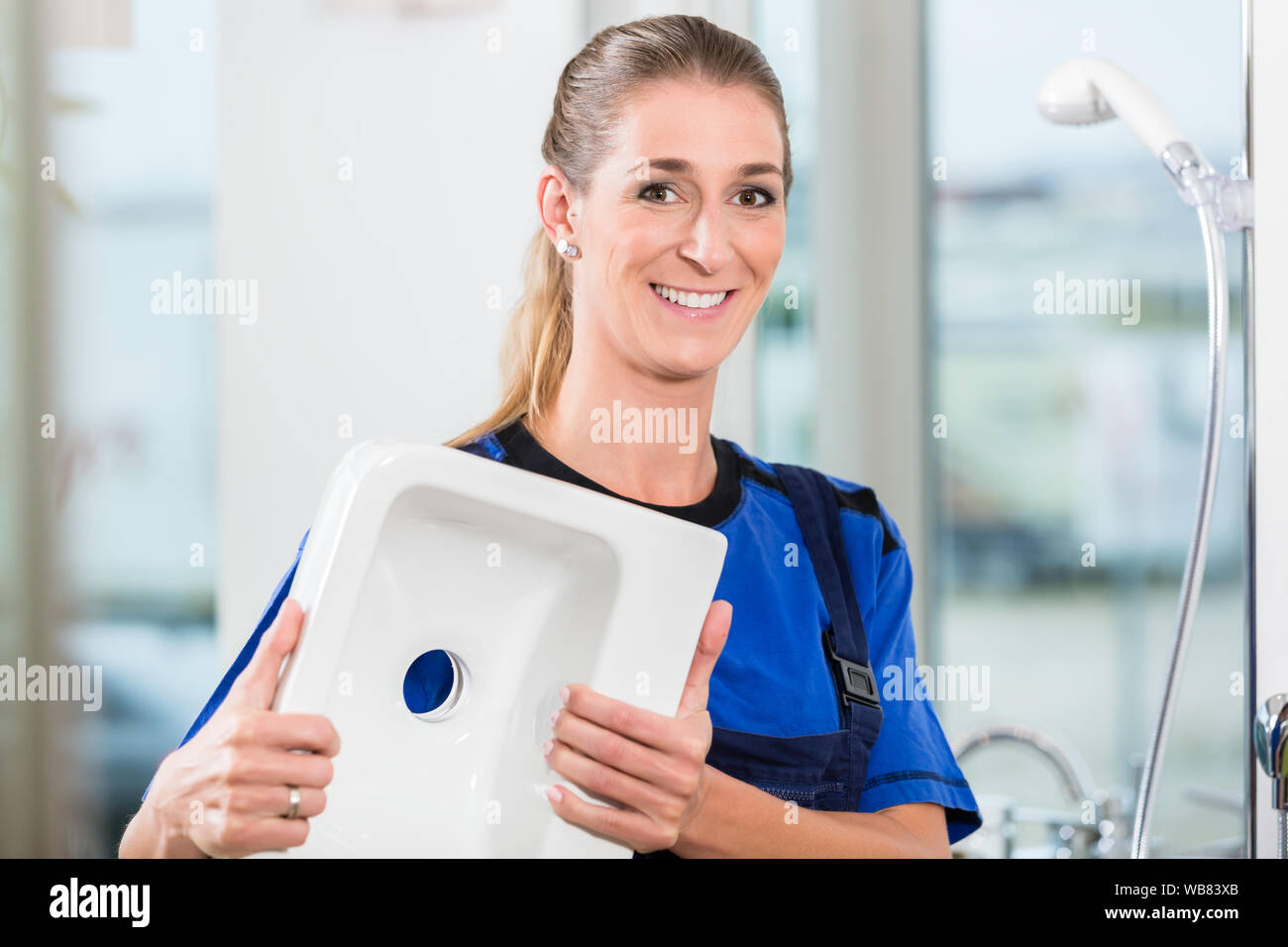 Lavoratore di sesso femminile che a lavorare in un negozio di sanitari con alta qualità in ceramica infissi Foto Stock