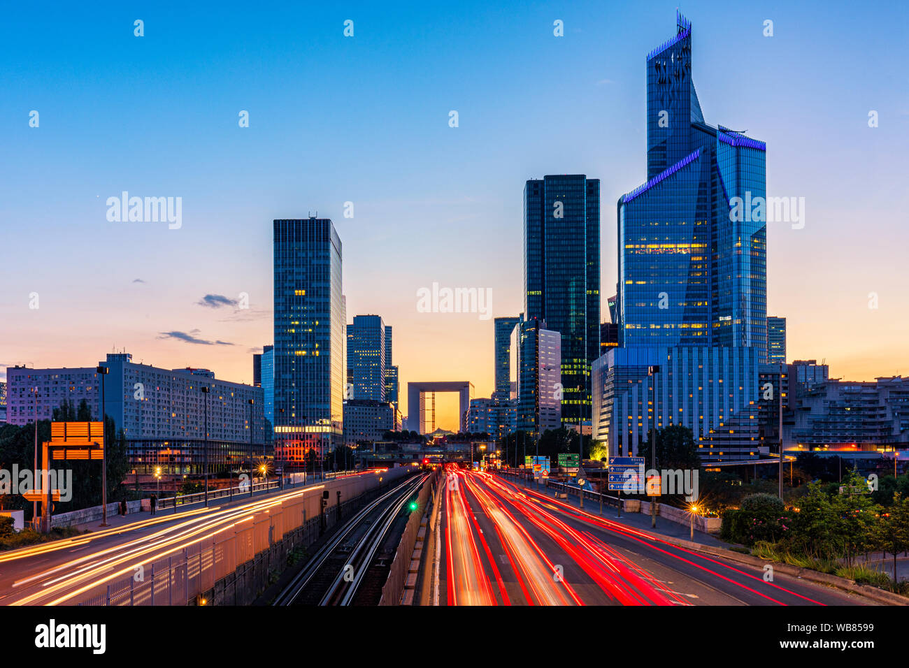 Grattacieli di La Defense moderno quartiere degli affari e finanziario di Parigi. Una lunga esposizione di multi-lane road con i grattacieli del quartiere degli affari La D Foto Stock