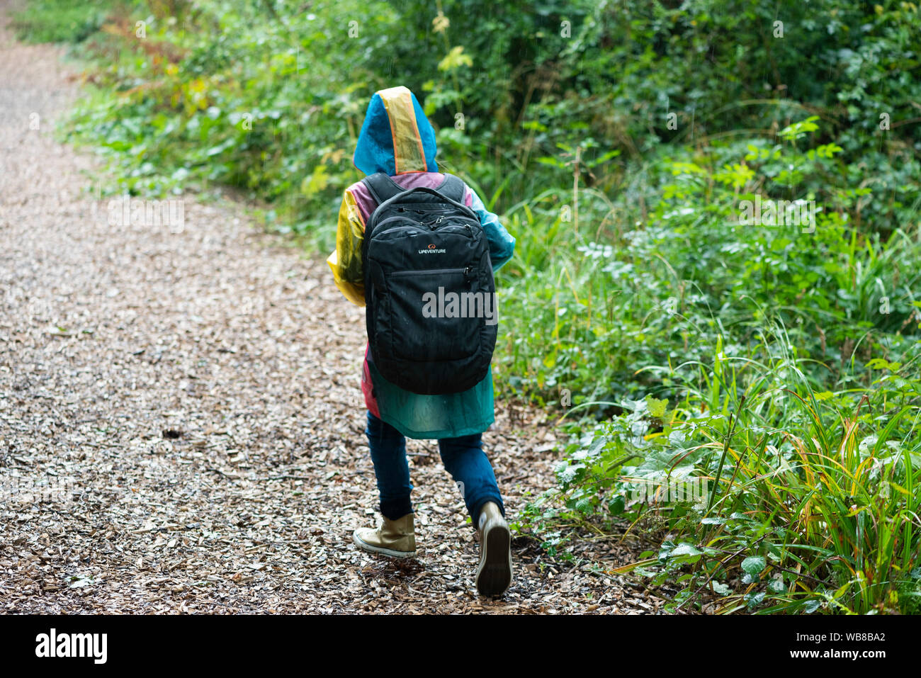 Bambino a piedi attraverso i boschi porta dimensione adulta zaino Foto Stock